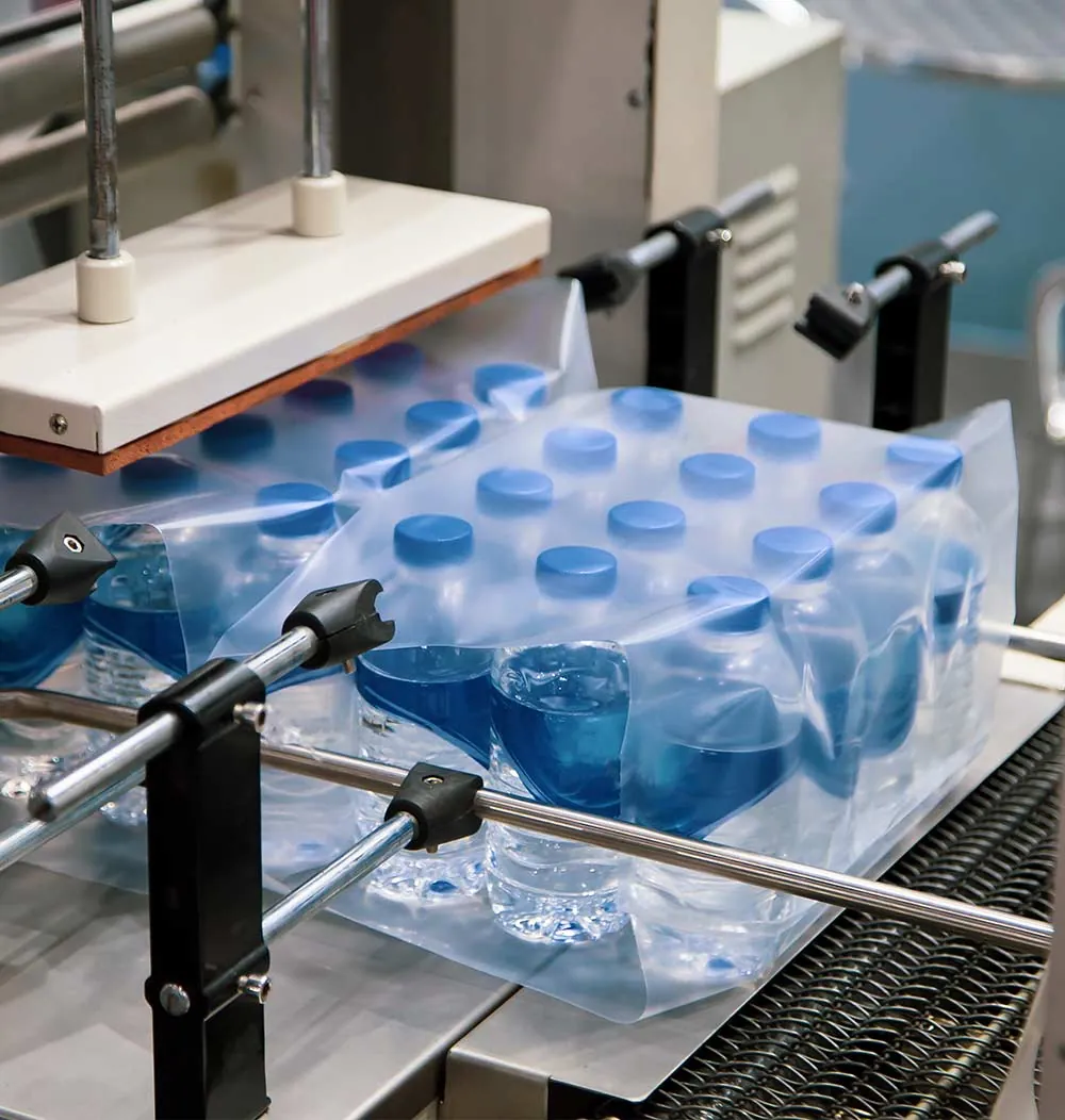 Water bottles being shrink wrapped in a shrink tunnel
